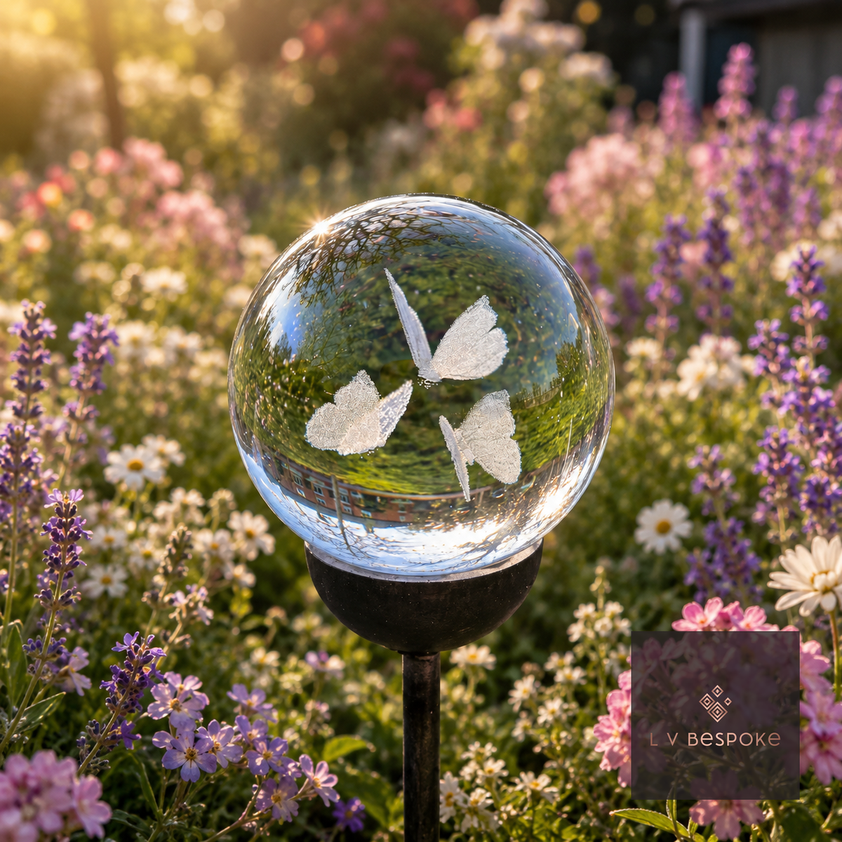 Raw steel garden stake with a clear glass orb holding a 3D Butterflies design, planted in a border