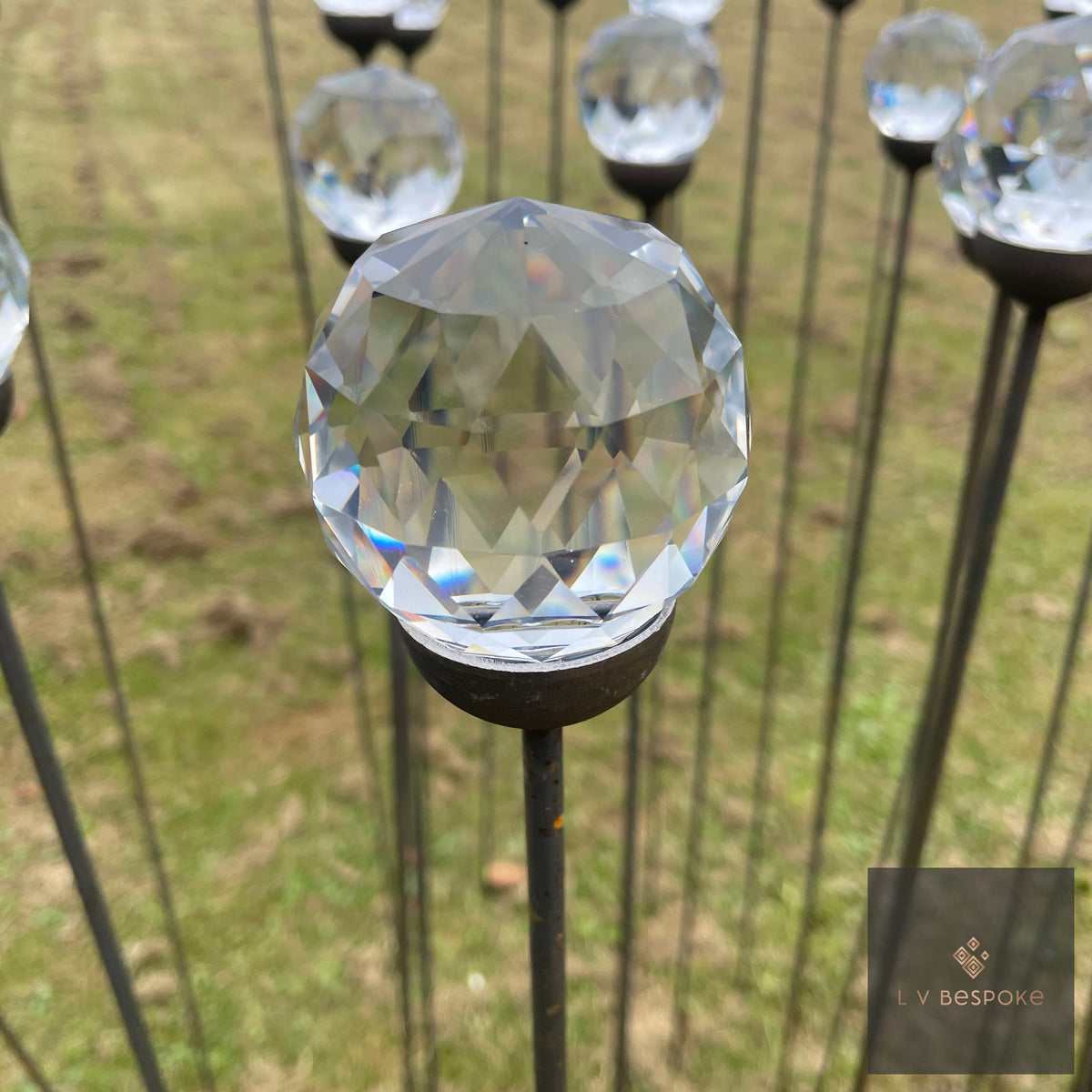 Close-up of a Prism finish faceted glass orb garden stake