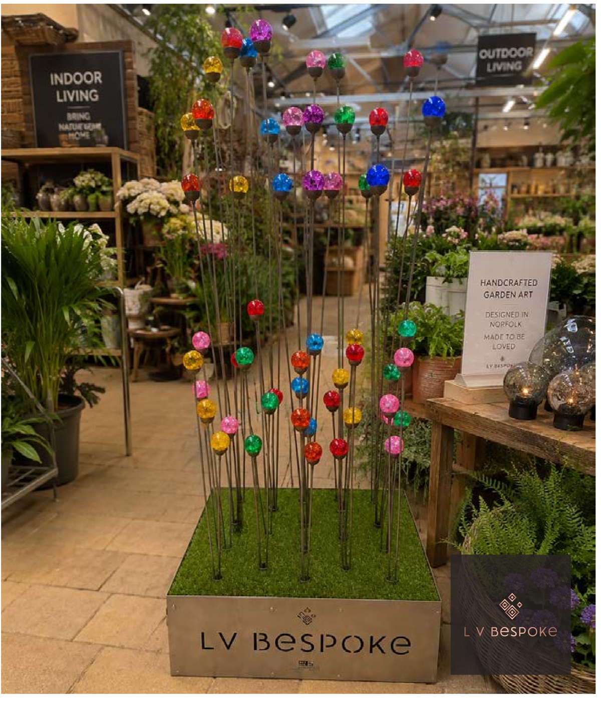Raw steel cluster of three garden stakes with coloured glass orbs, shown in a mixed display