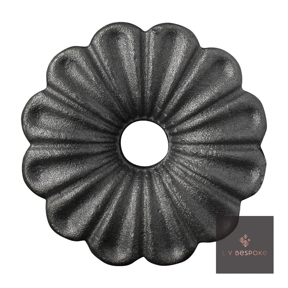 Raw steel Gerbera flower head on a garden stake, planted in a border