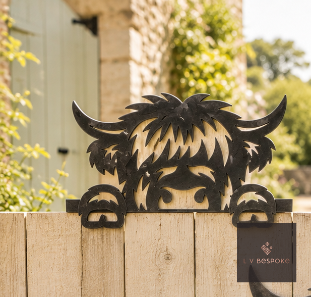 Raw steel Highland Cow Peeking Over Fence wall art on a garden wall
