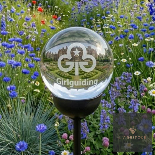 Glass sphere with Girlguiding logo in a garden setting