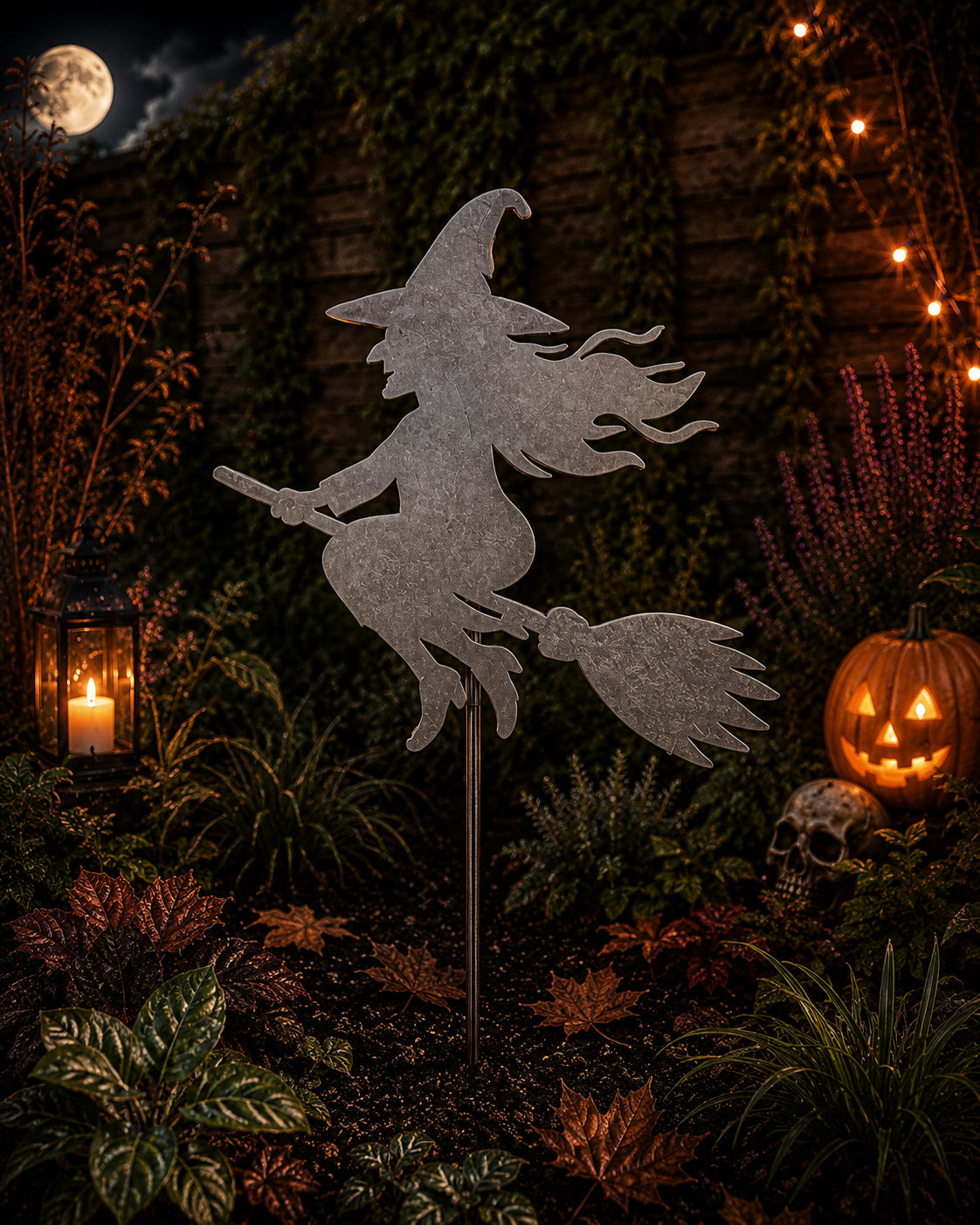 Raw steel witch on a broomstick Halloween garden stake with pointed hat