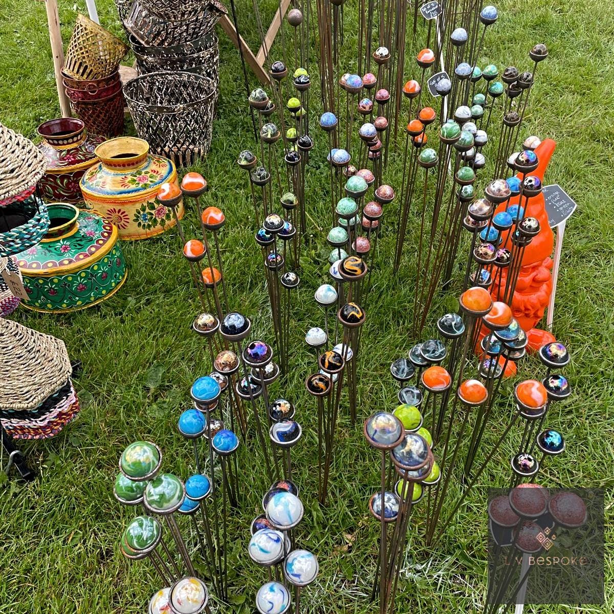 Marble sun catcher garden stakes in many colours displayed on a lawn