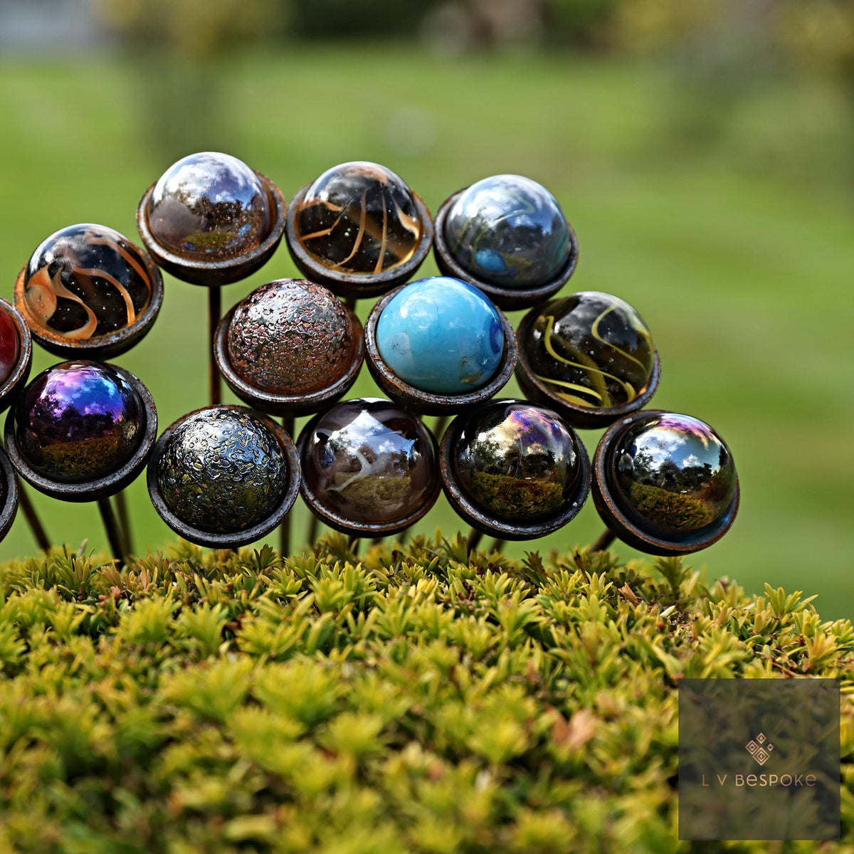Glass marble sun catcher tops grouped together above a low hedge