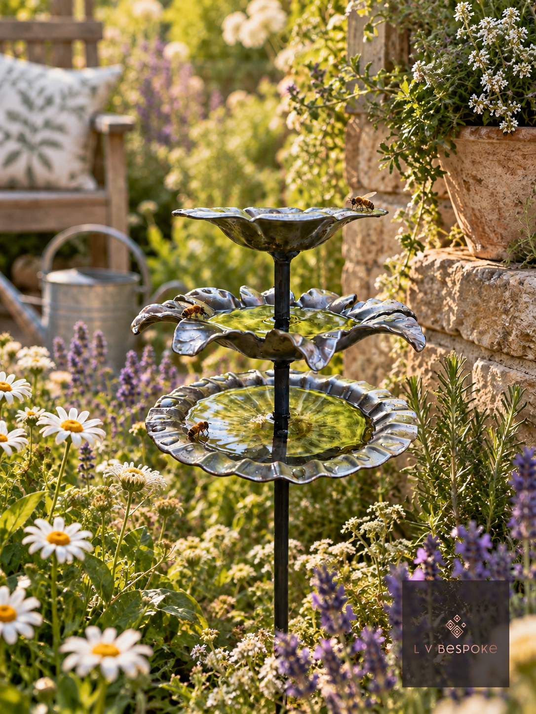 Floral finish triple tier bee drinker filled with rainwater in a sunny border